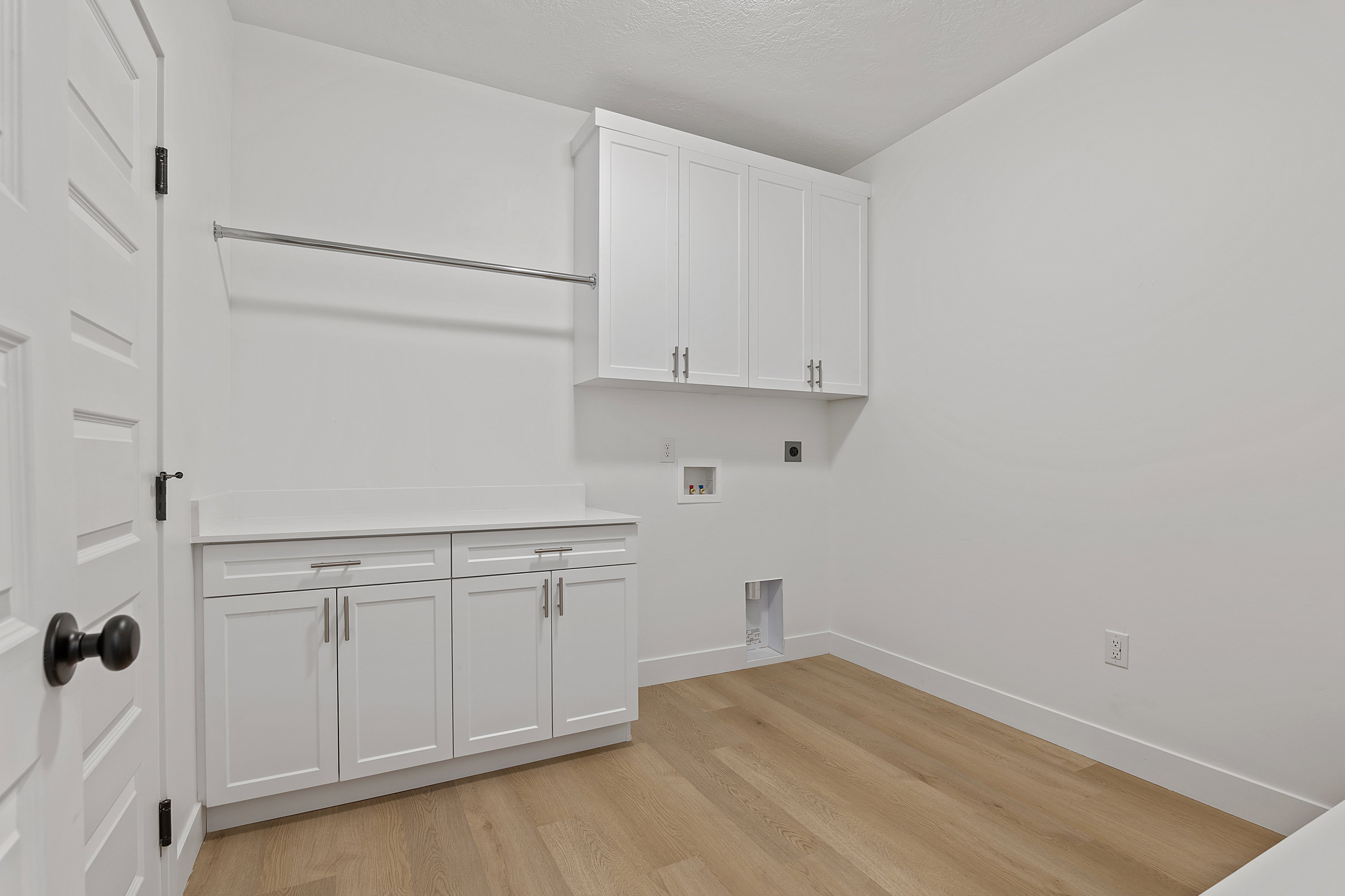 Washroom featuring hookup for an electric dryer, light wood finished floors, cabinet space, and hookup for a washing machine