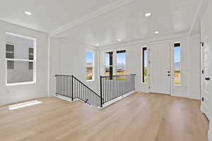 Foyer with light wood-style floors, plenty of natural light, and recessed lighting