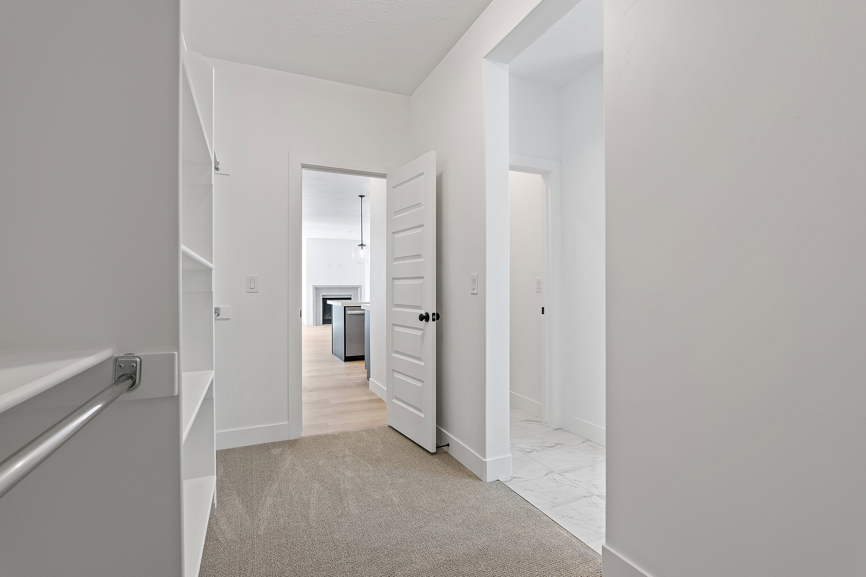 Hallway featuring light marble finish flooring and baseboards