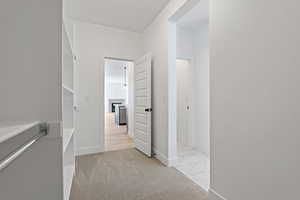 Hallway featuring light marble finish flooring and baseboards
