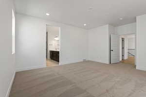 Unfurnished bedroom featuring light colored carpet, recessed lighting, and ensuite bathroom