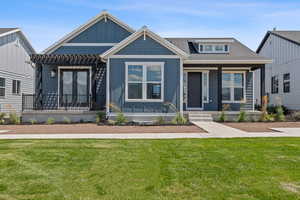 View of front of home with a pergola, a front yard, a shingled roof, and french doors