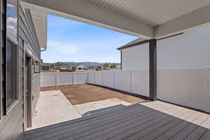 Wooden terrace featuring a fenced backyard, a patio area, and a residential view