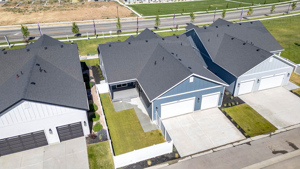 Contemporary home featuring a blue siding exterior, dark shingle roof, two-car garage, concrete driveway, and a covered back patio