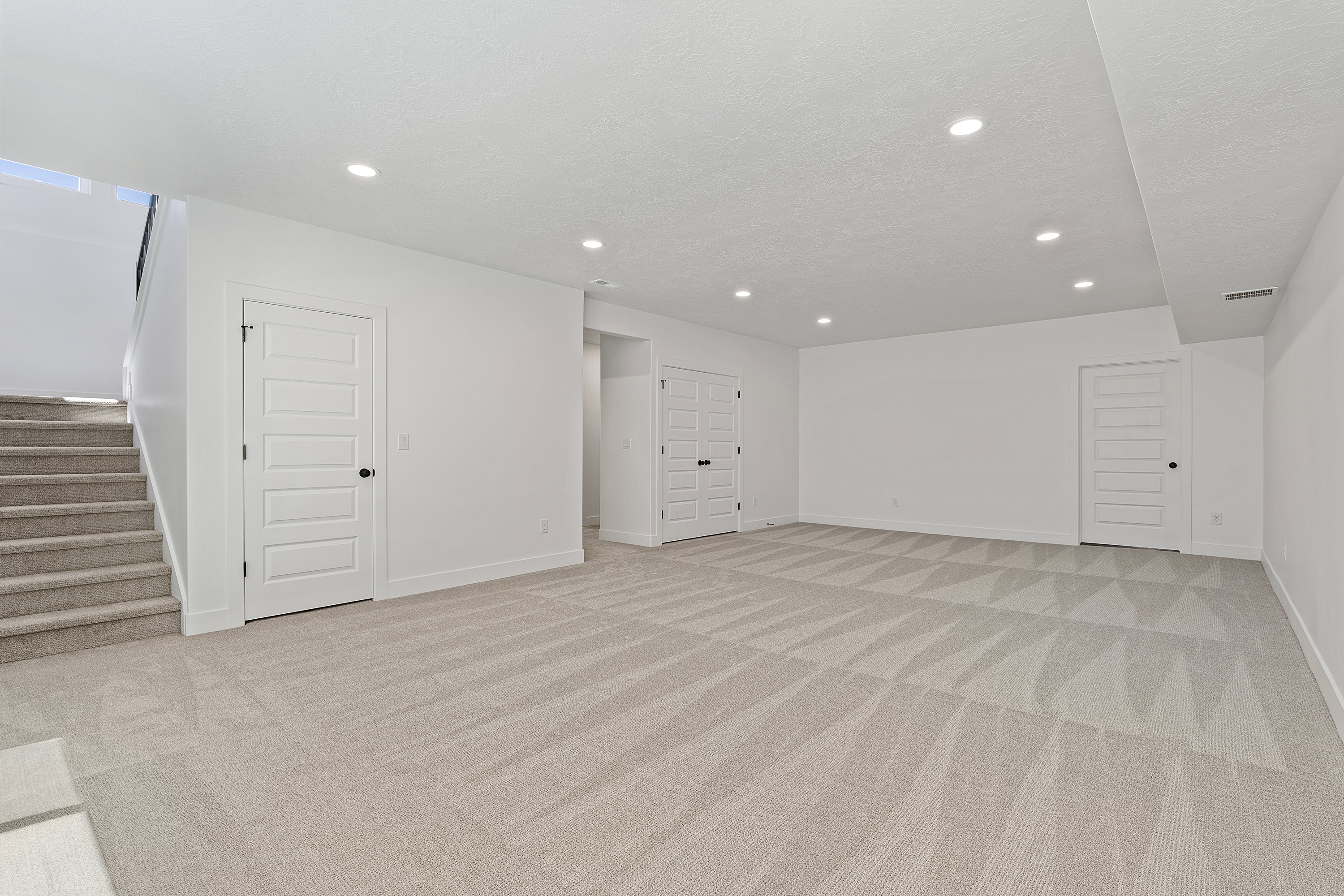 Basement featuring stairs, light carpet, and recessed lighting