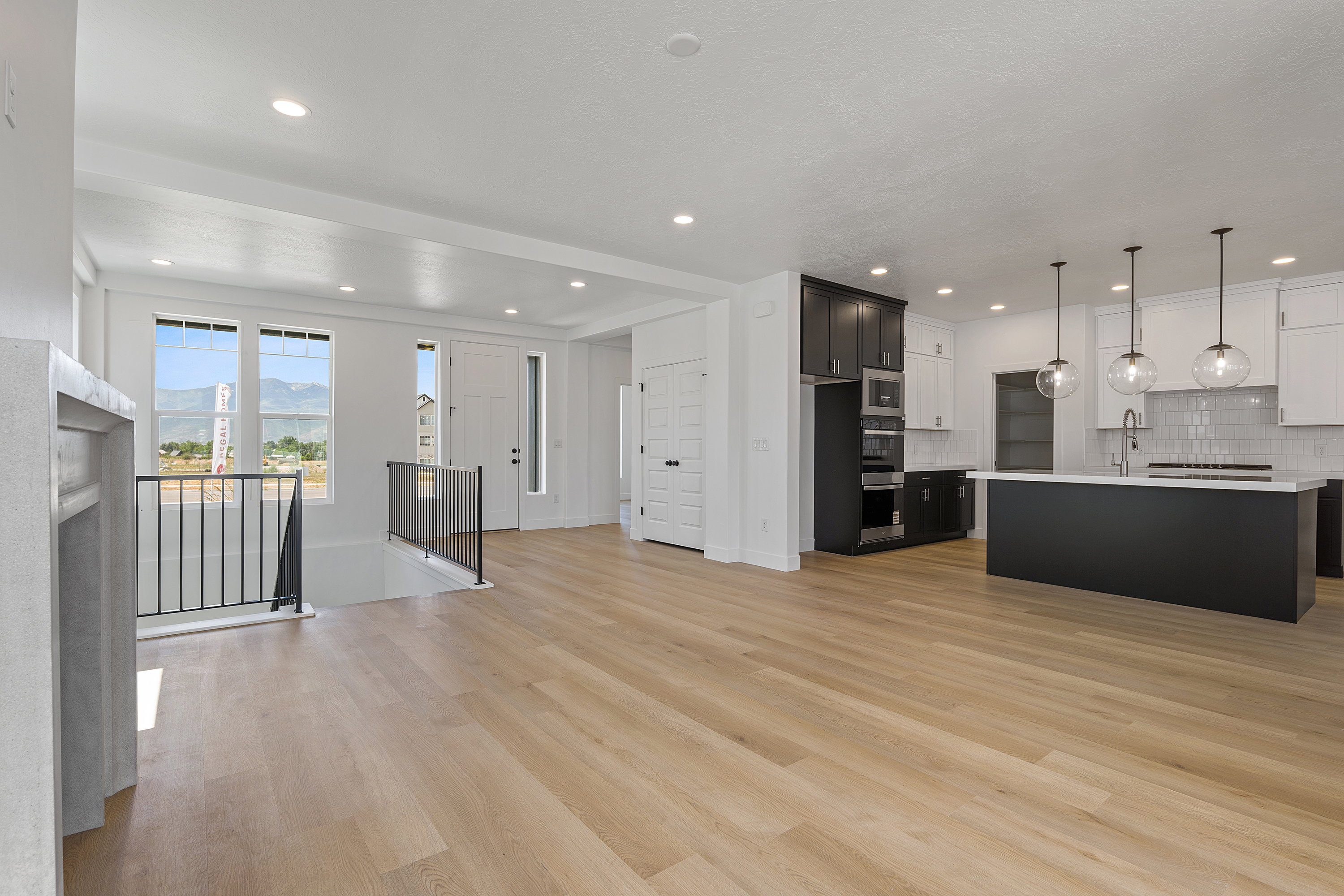 Kitchen with open floor plan, light countertops, tasteful backsplash, light wood-style floors, and recessed lighting