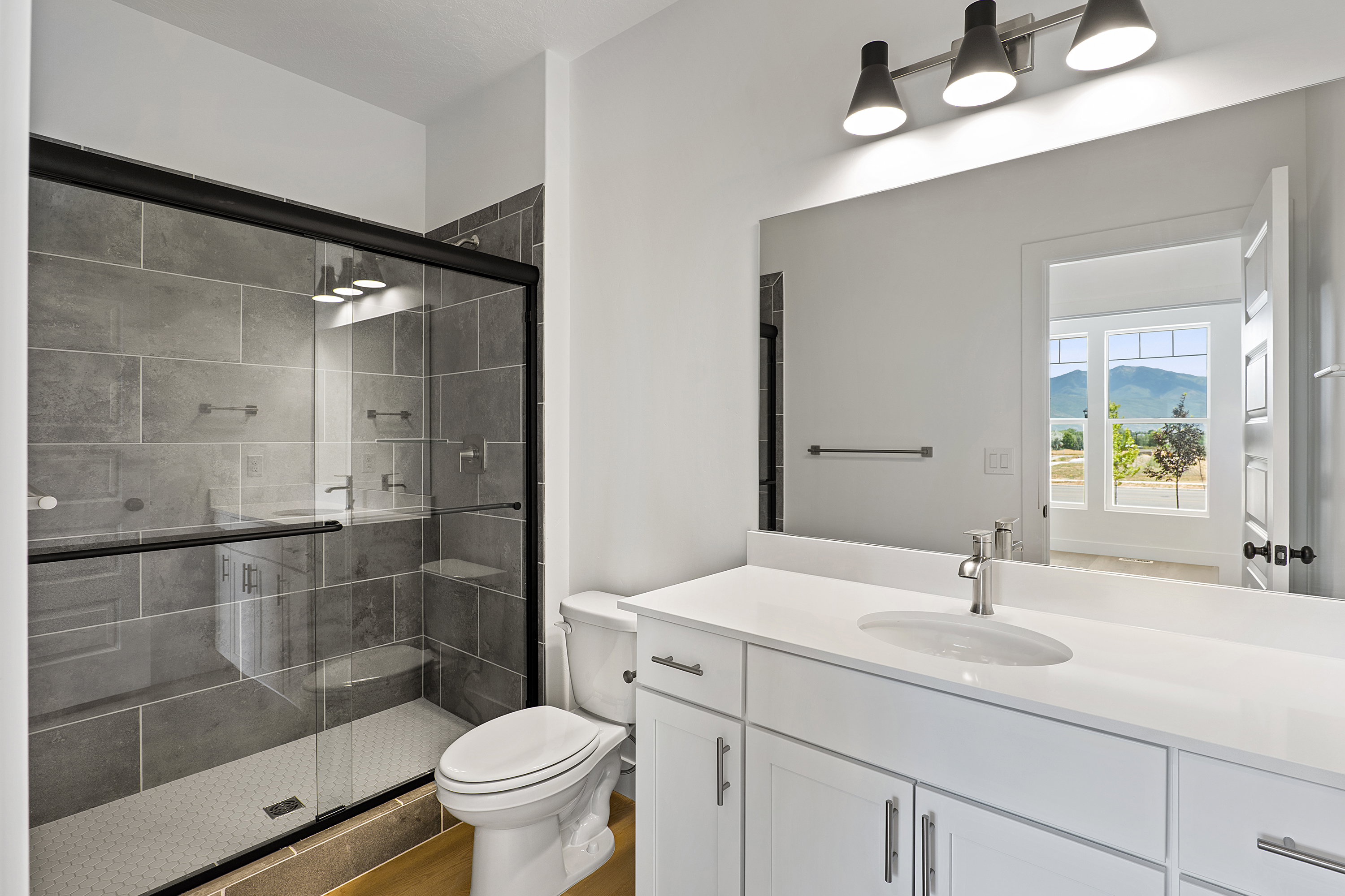Full bath featuring vanity, a shower stall, a mountain view, and wood finished floors