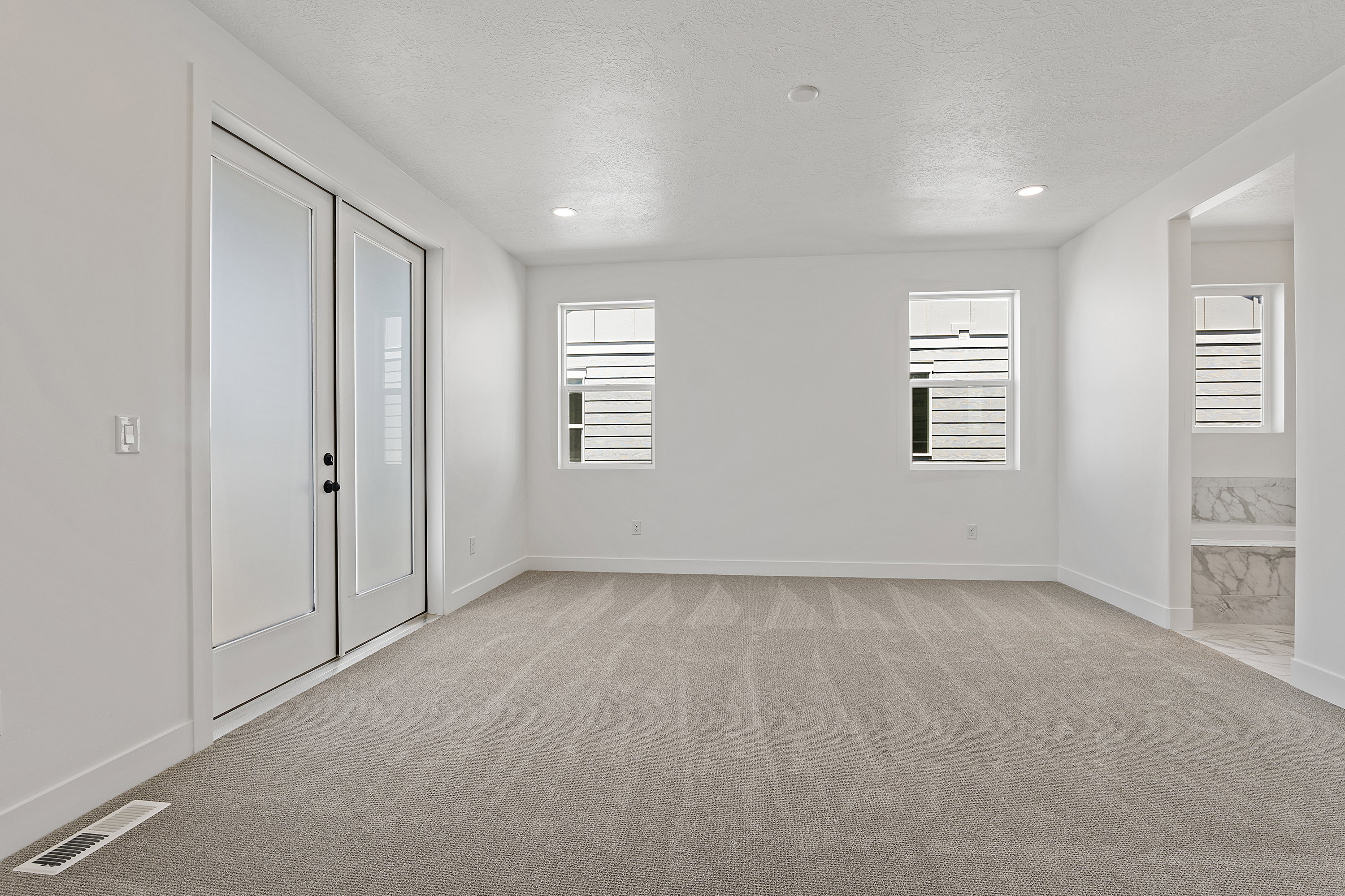 Spare room with light colored carpet, a textured ceiling, and recessed lighting