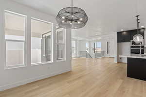 Unfurnished dining area featuring light wood-style floors, a chandelier, and recessed lighting