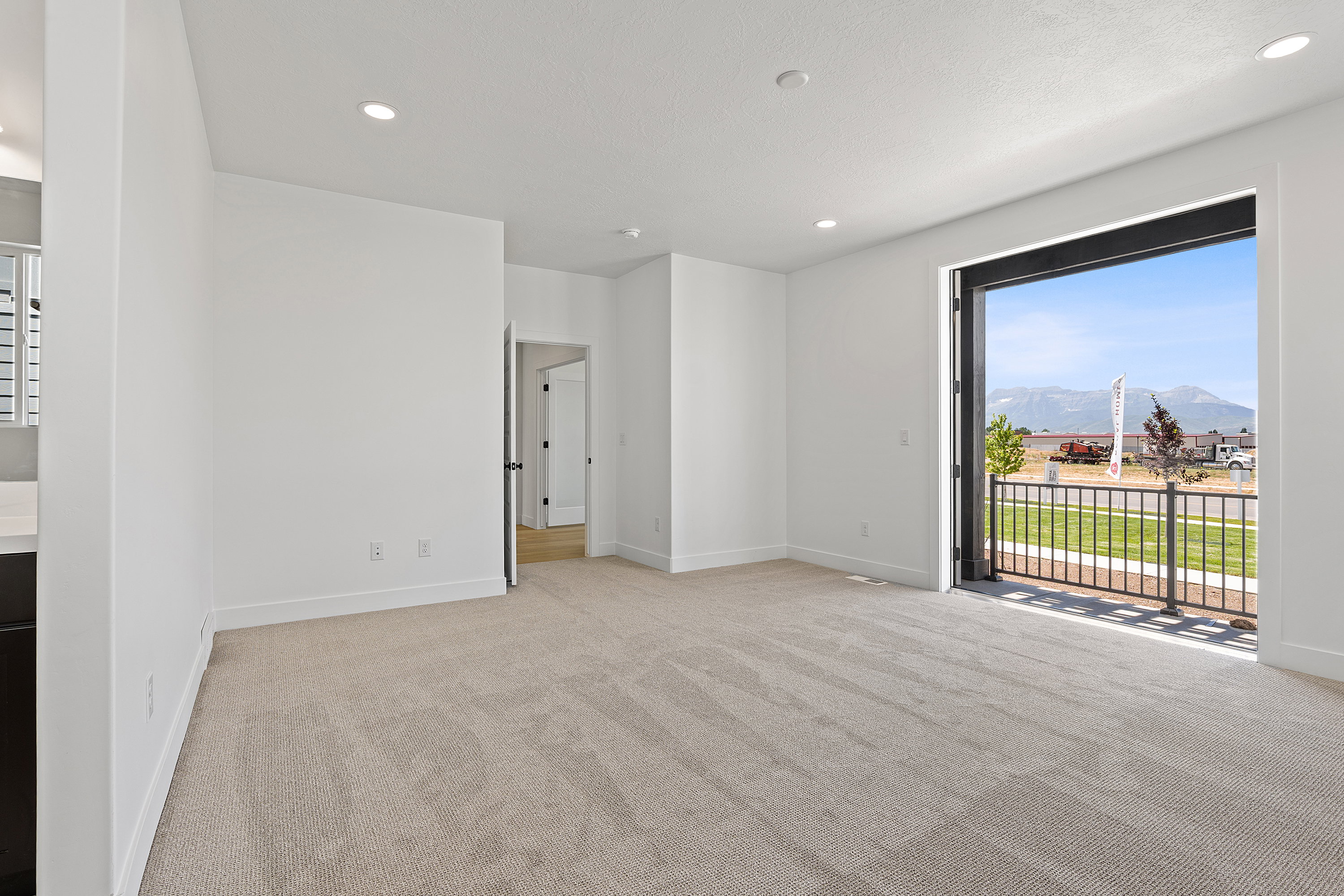 Unfurnished bedroom featuring a mountain view, carpet, access to exterior, and recessed lighting