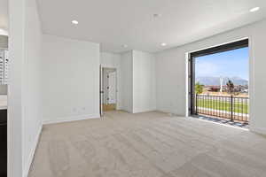 Unfurnished bedroom featuring a mountain view, carpet, access to exterior, and recessed lighting