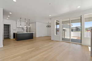 Unfurnished living room featuring light wood-style flooring, recessed lighting, and a chandelier