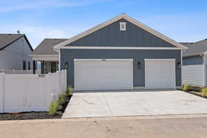 View of front facade featuring board and batten siding and concrete driveway