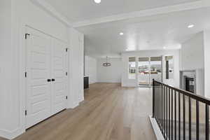 Corridor featuring light wood finished floors, recessed lighting, and a chandelier
