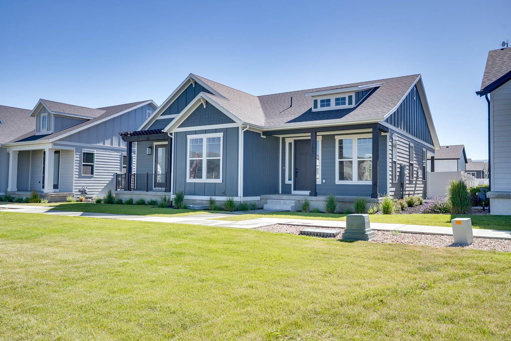 Modern ranch-style home featuring a dark gray exterior with white trim