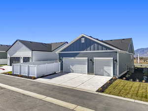 View of front of house with board and batten siding, concrete driveway, a shingled roof, and an attached garage