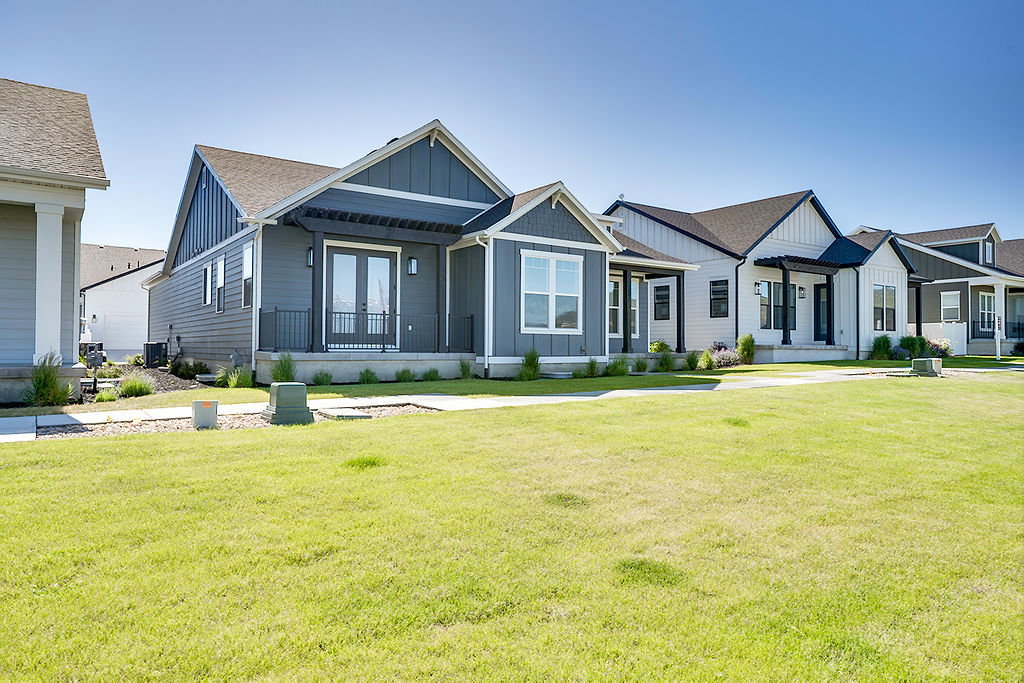 Modern farmhouse-style exterior featuring a striking dark gray siding and white trim