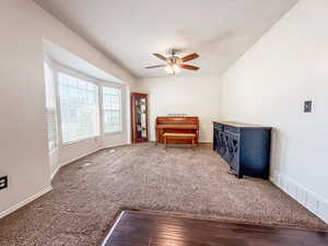 Living area featuring a ceiling fan and carpet flooring