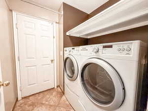 Washroom featuring washer and dryer and light tile patterned floors
