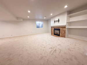 Unfurnished living room with carpet flooring, a fireplace, and recessed lighting