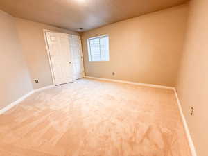 Unfurnished bedroom featuring baseboards and light colored carpet