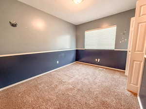 Carpeted spare room with baseboards