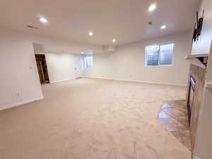 Basement with a tile fireplace, light carpet, and recessed lighting