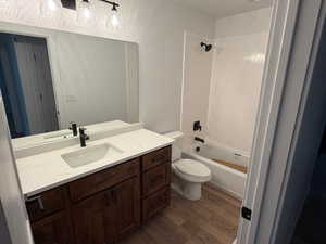 Bathroom with dark wood-style floors, vanity, and shower / bath combination
