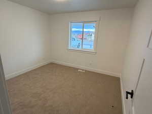 Unfurnished room featuring carpet floors and baseboards