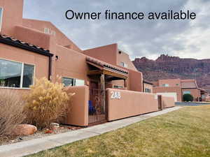 View of property exterior featuring a fenced front patio, stucco siding, a gate, and a mountain view