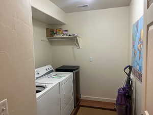 Washroom with washing machine and clothes dryer and a textured wall