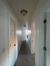 Hallway featuring carpet flooring and fresh paint.