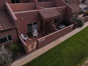 Back of house featuring a tile roof and stucco siding