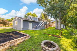 Rear view of house featuring a fire pit, stucco siding, a storage shed, and a patio area