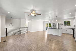 Unfurnished living room with crown molding, light wood finished floors, recessed lighting, and ceiling fan