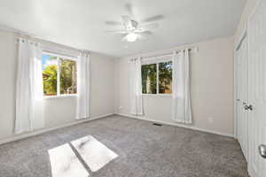 Unfurnished bedroom featuring carpet, a closet, and a ceiling fan