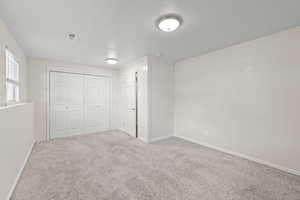 Unfurnished bedroom with carpet flooring and a closet