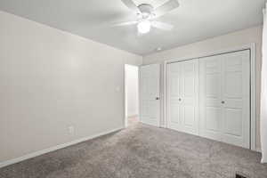 Unfurnished bedroom with carpet floors, a closet, and ceiling fan