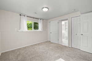 Unfurnished bedroom featuring carpet and connected bathroom