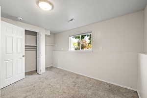 Unfurnished bedroom featuring carpet flooring and a closet