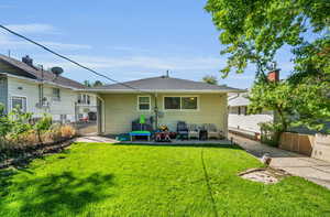 Back of house with a gate, a patio, and roof with shingles