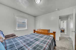 Bedroom featuring carpet floors and a textured ceiling