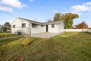 Back of house featuring a patio, brick siding, and a fenced backyard