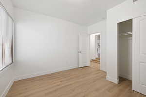 Unfurnished bedroom with light wood-type flooring and a closet