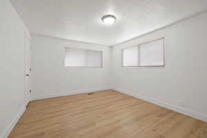 Spare room featuring light wood finished floors and a textured ceiling