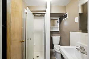 Full bath featuring a stall shower and wood-style vinyl flooring.