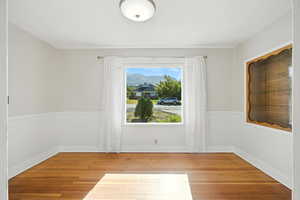 Dining room with hardwood floors and wainscoting. Features large east-facing windows.