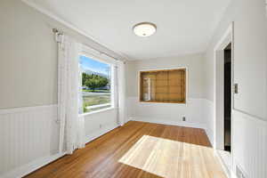 Dining room with hardwood flooring and wainscoting.