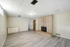 Basement living room with light wood-style vinyl flooring.