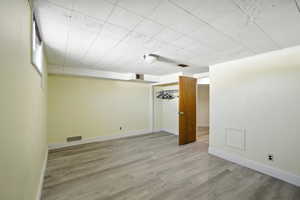 Basement bedroom with wood-style vinyl flooring.